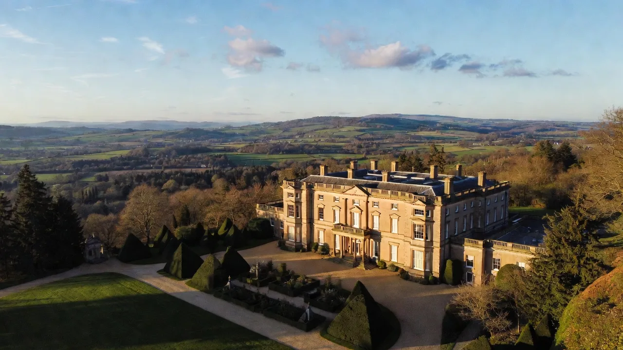 A Cotswold stone manor house above rolling countryside in the Cotswolds