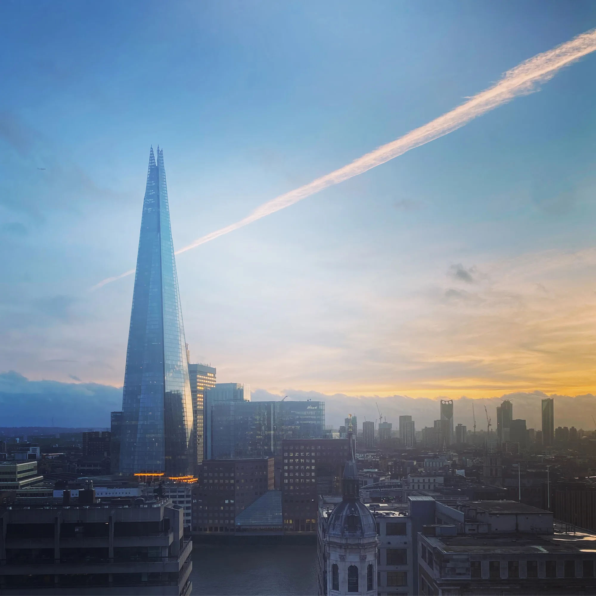 The Shard above the London skyline at sunset, seen across the rooftops of Southwark