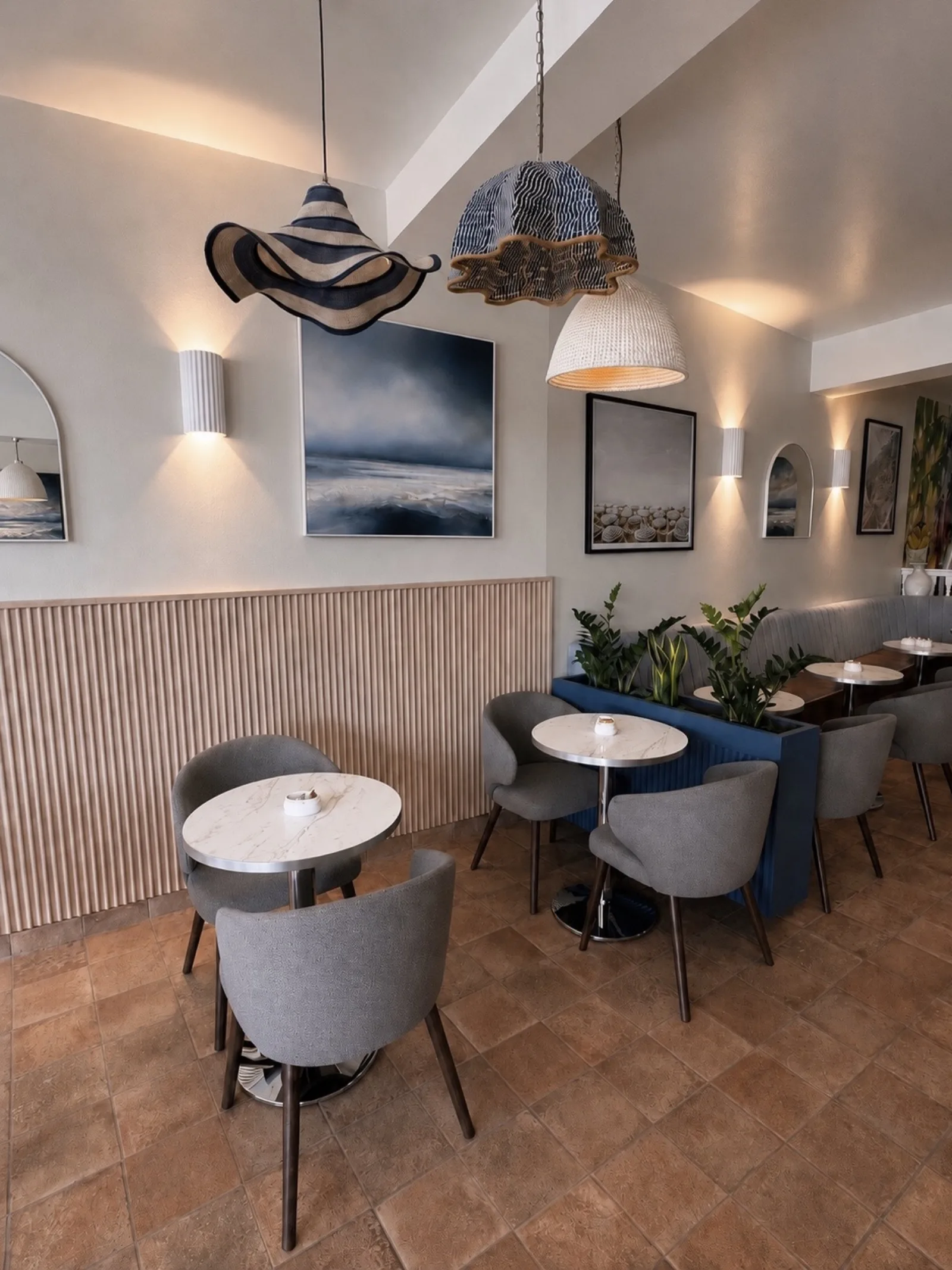 Round marble tables and fluted timber panelling in the cafe seating area