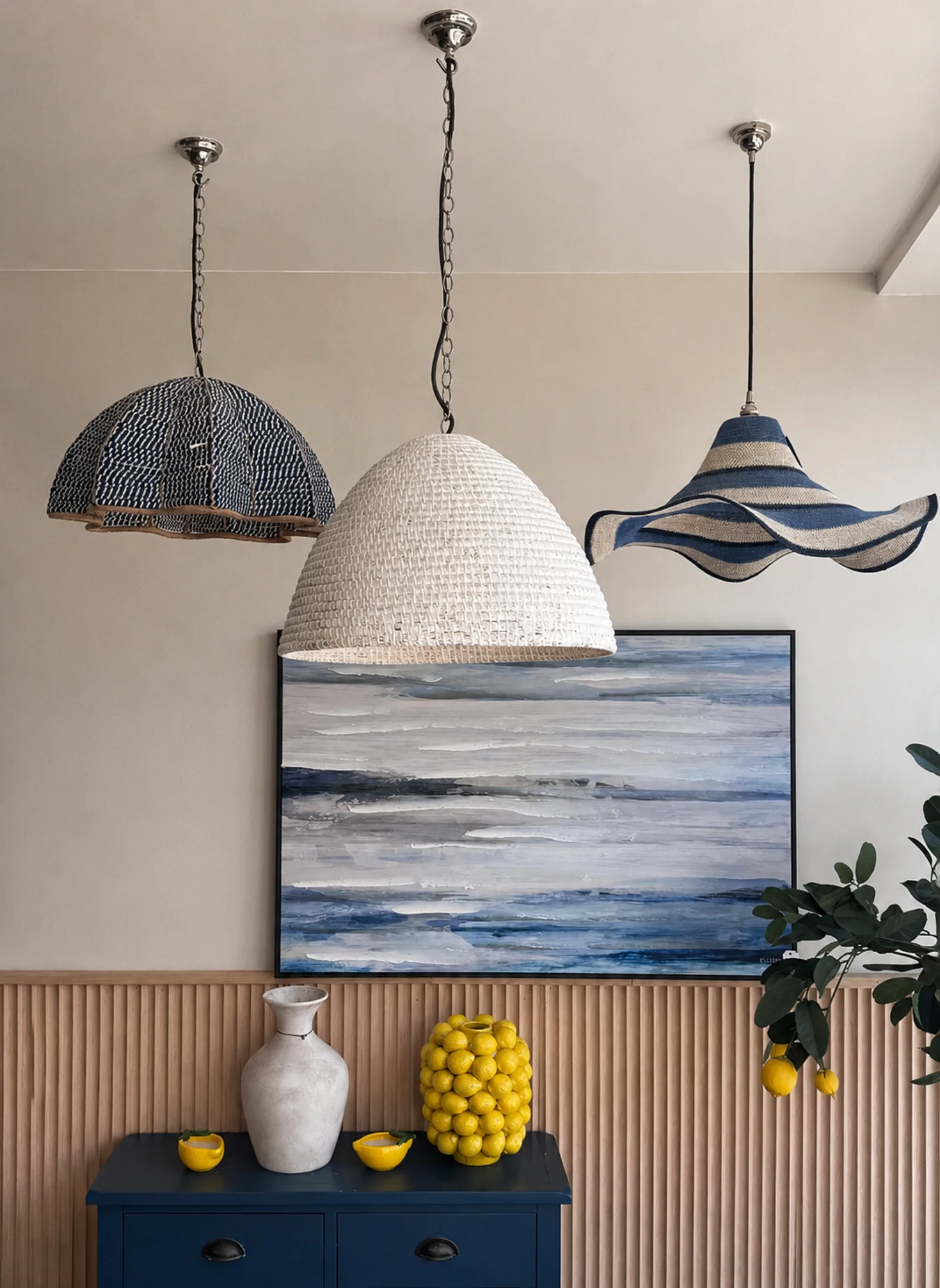 Woven pendant lights above a seascape painting