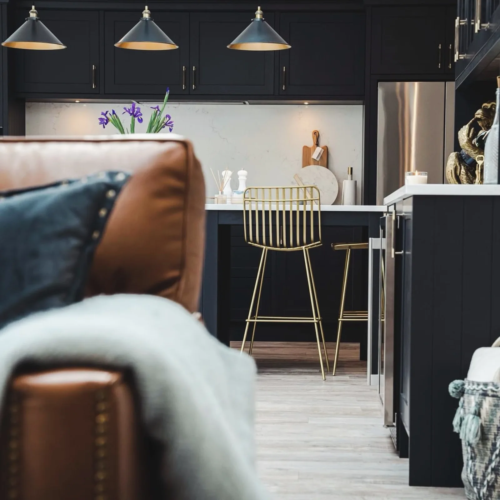 Brass bar stools and a leather cushion at the kitchen island