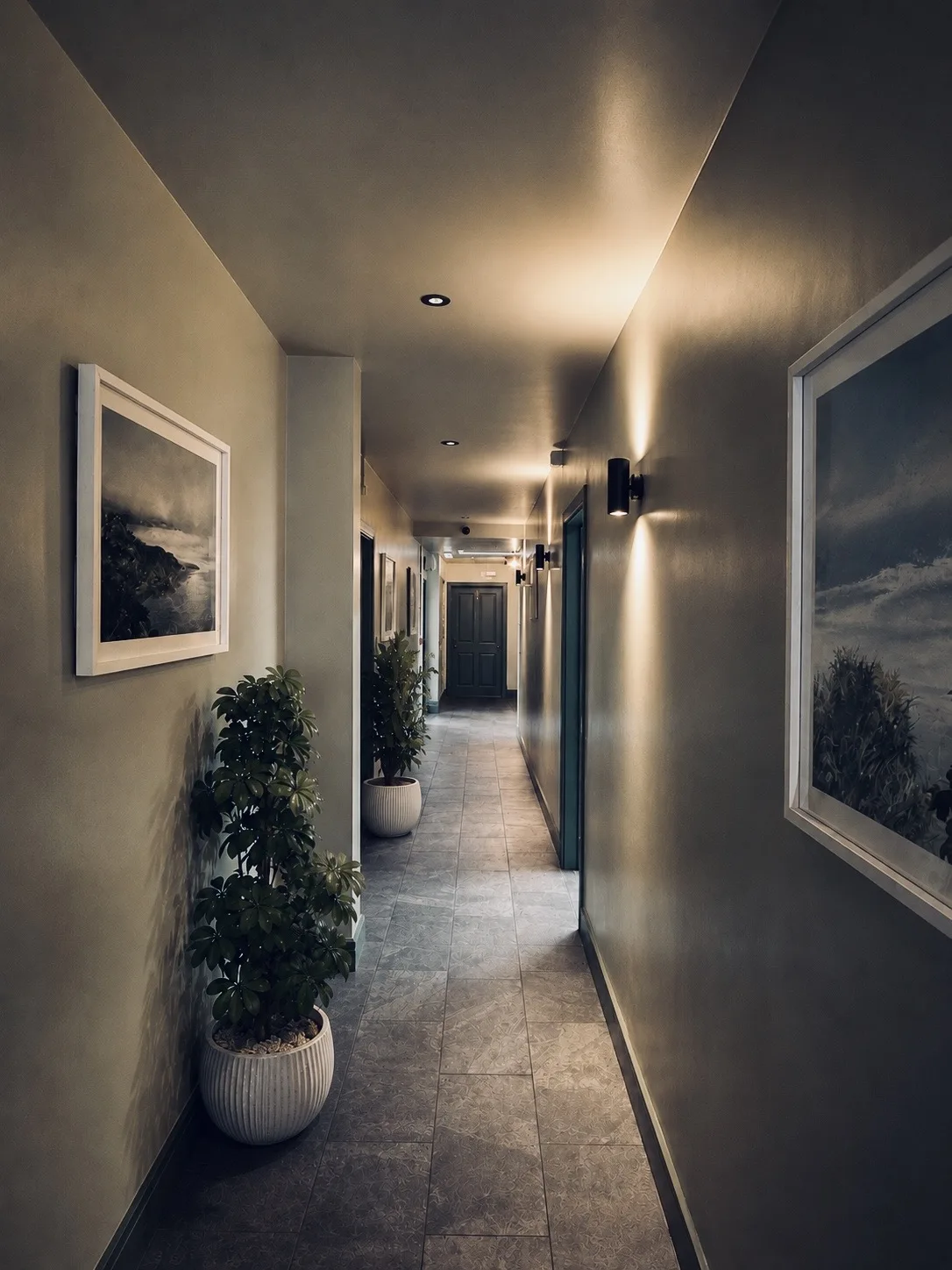 Lit corridor with framed coastal prints and potted plants, Belluno Restaurant, Bideford, Devon