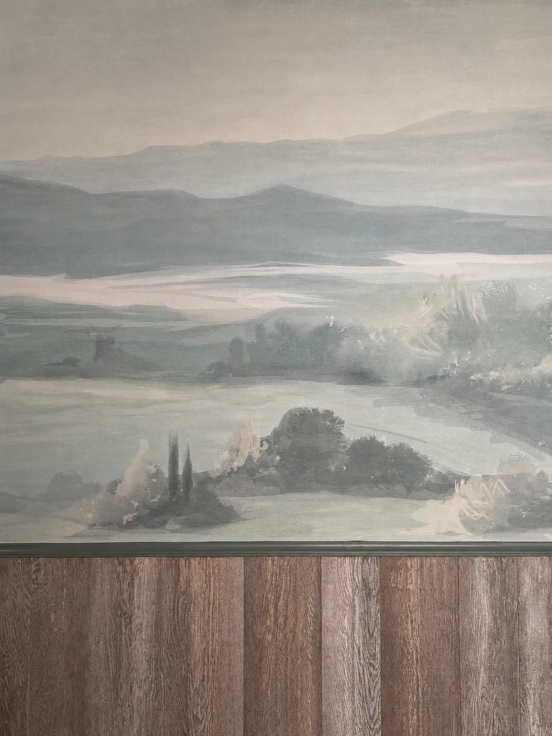 Painted Tuscan landscape mural above timber wall panelling in the function room, Belluno Restaurant, Bideford, Devon