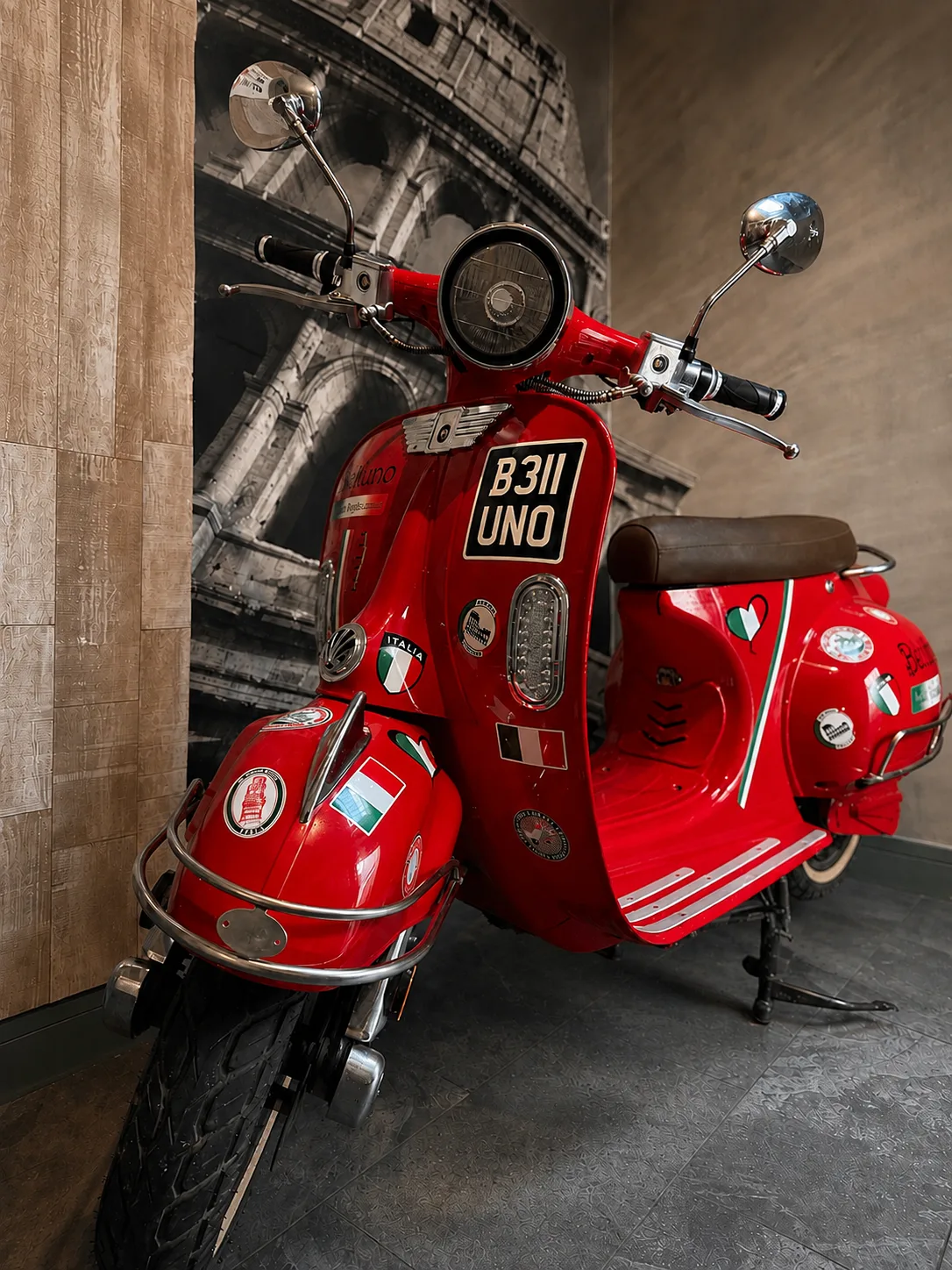 Red Belluno branded Vespa parked in the corridor against the Colosseum wallpaper, Belluno Restaurant, Bideford, Devon