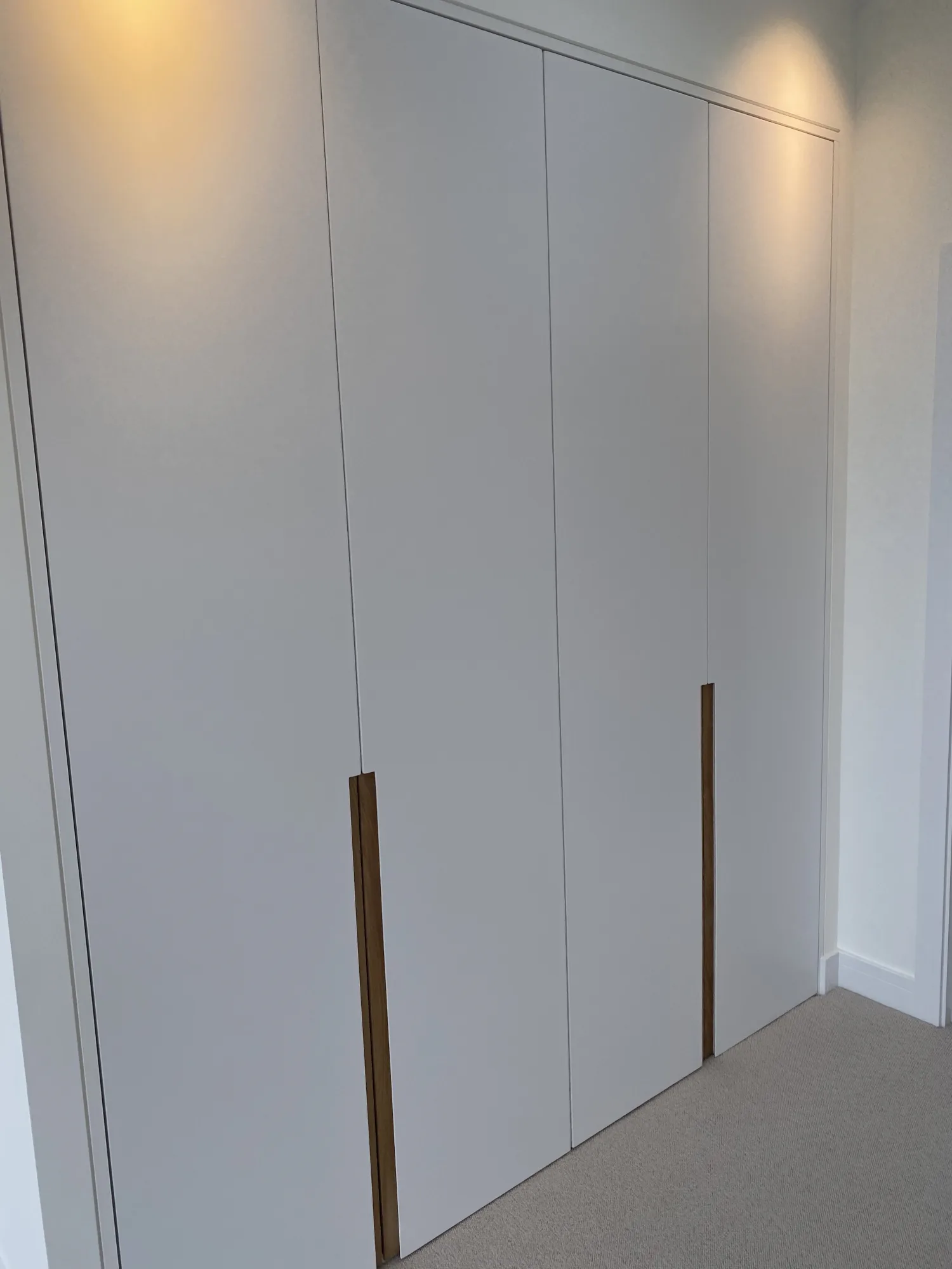 Bespoke fitted wardrobes in matt white with slim oak pull handles, Northam, Devon