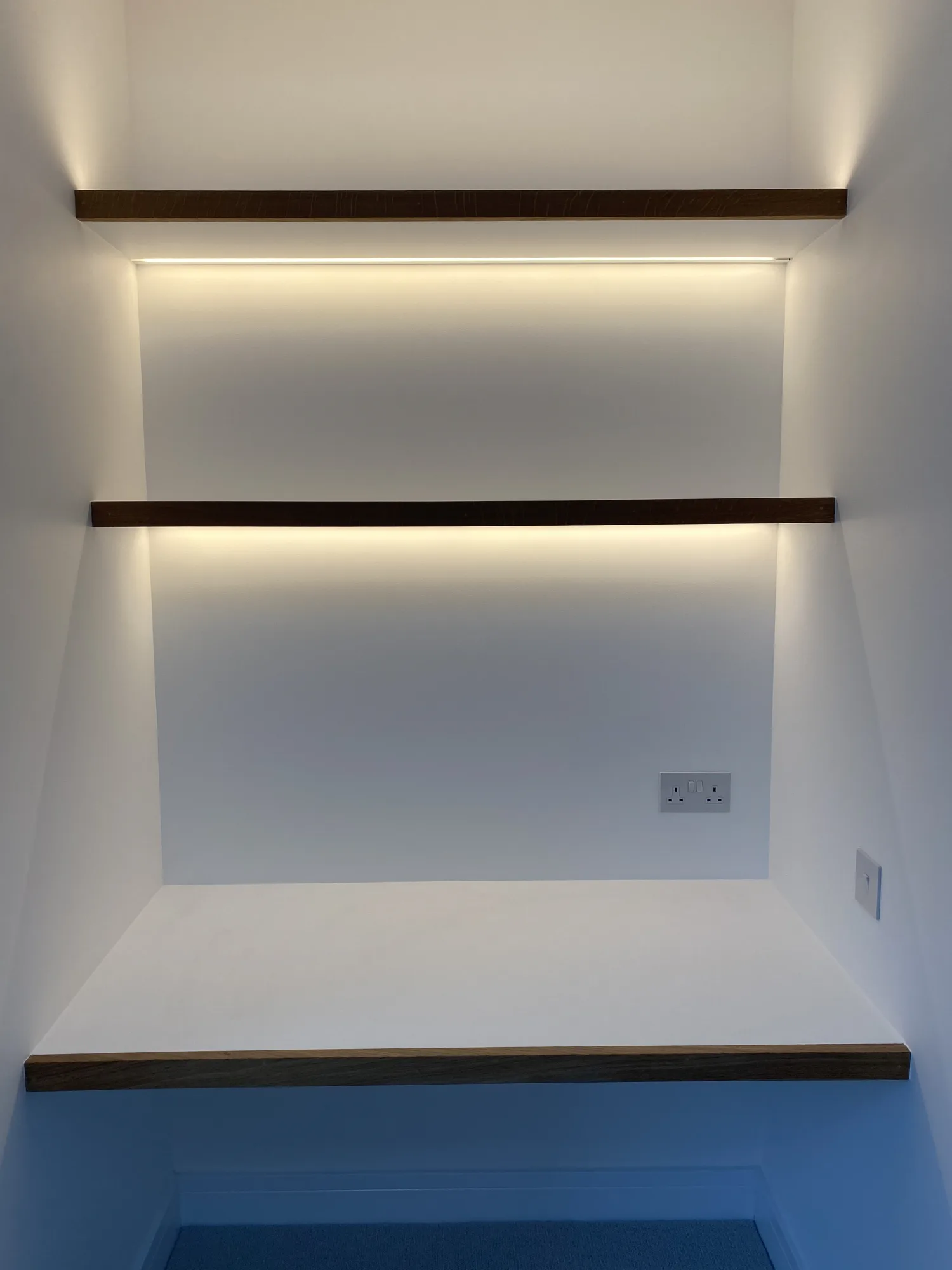 Custom built desk and walnut shelving with concealed lighting in a child's room, Northam, Devon