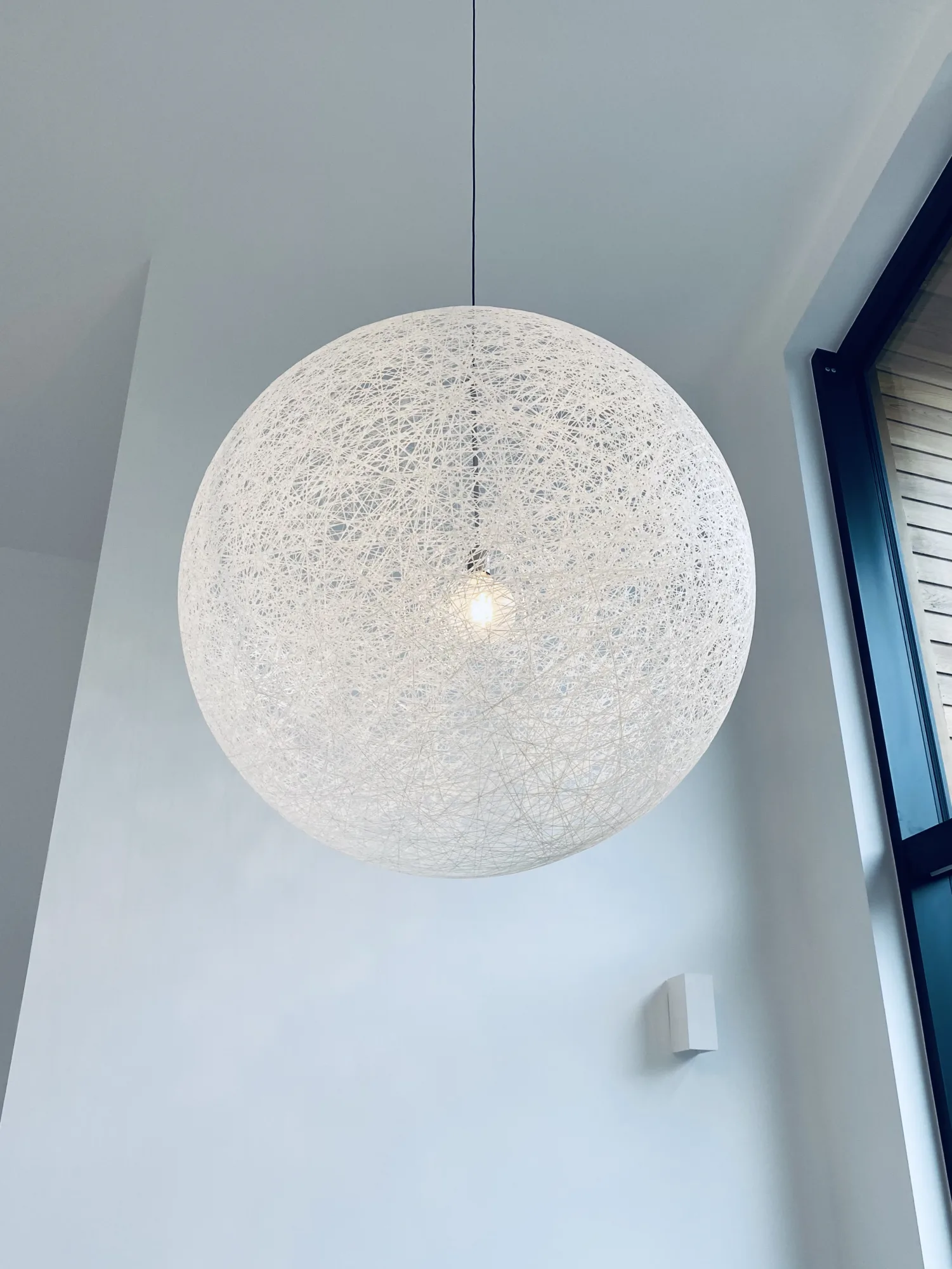White Moooi Random pendant light hanging in a double height stairwell, Northam, Devon