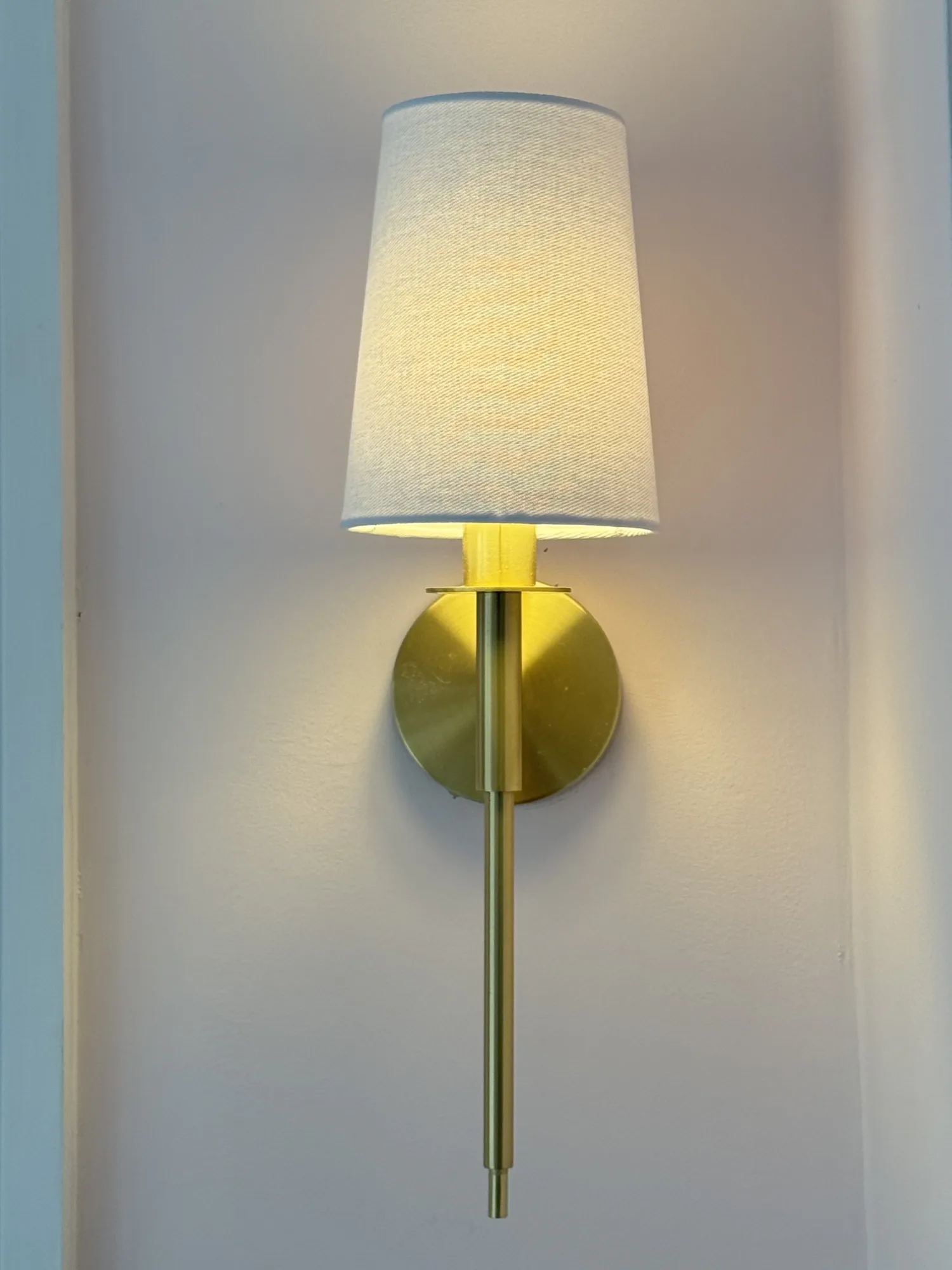 Amos Westminster wall light in satin brass with a white fabric shade, Stevenstone, Devon