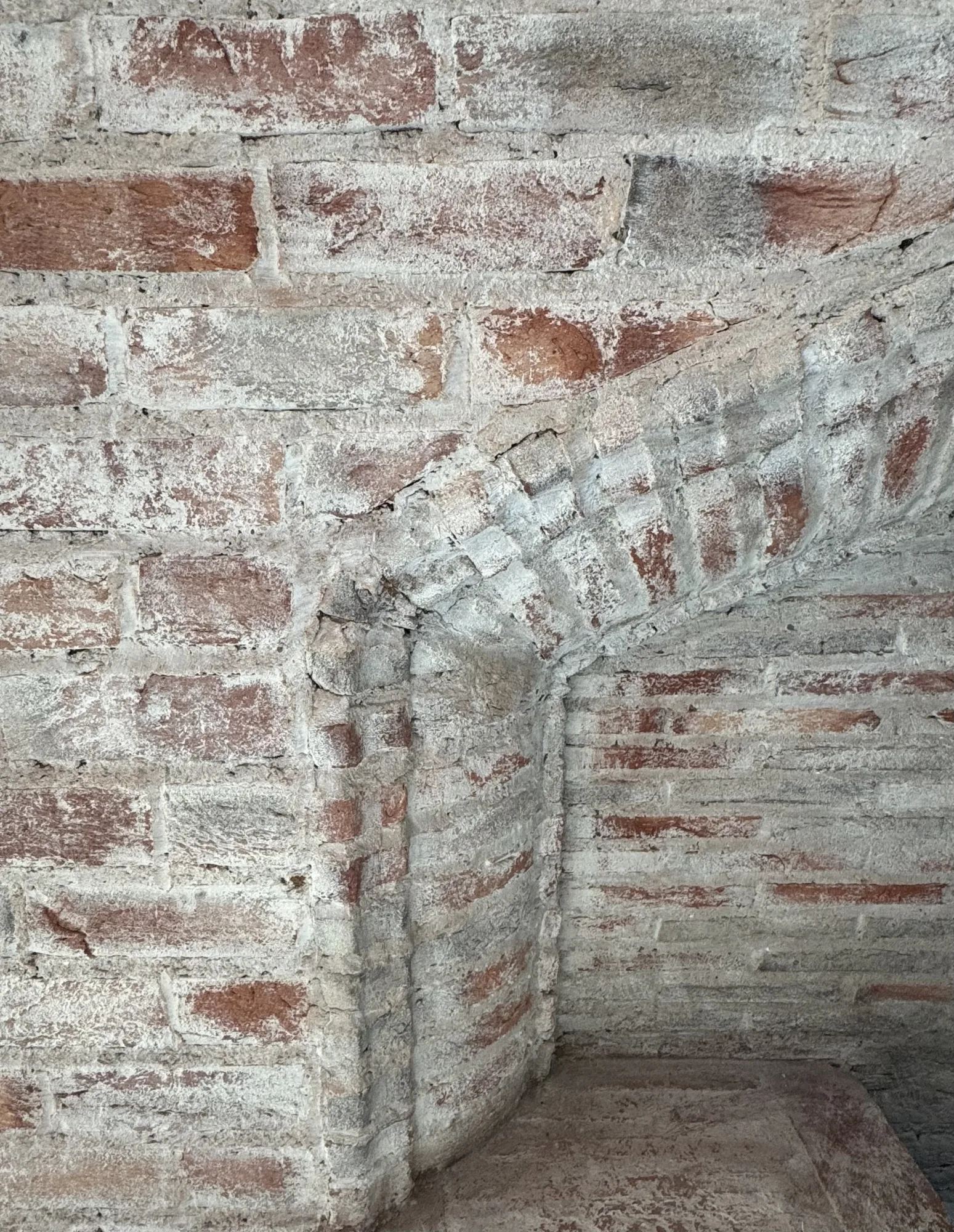 Limewashed brick fireplace arch in the converted stable block, Stevenstone, Devon