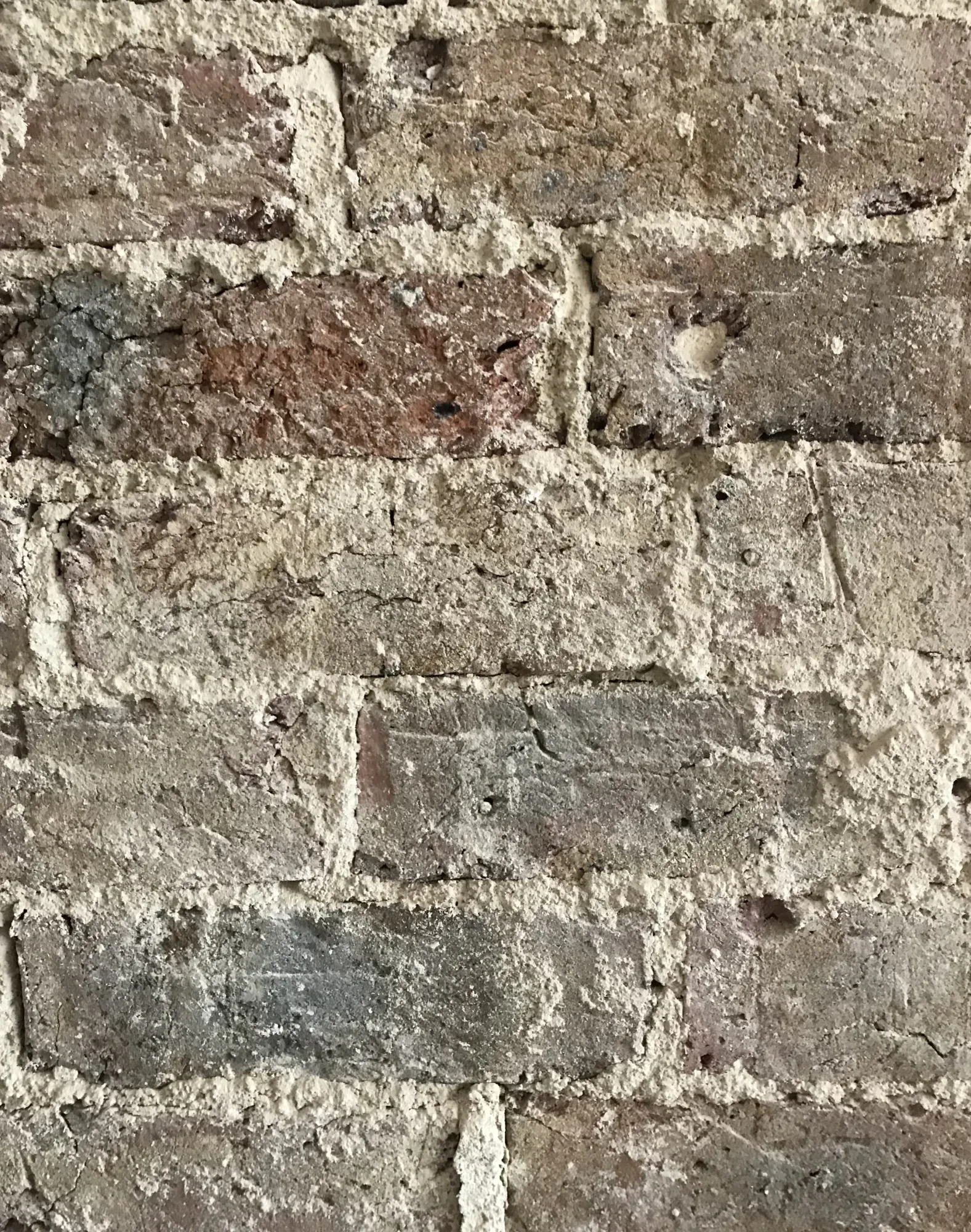 Original exposed brick wall, left bare and lime pointed, at Ethos HQ in London