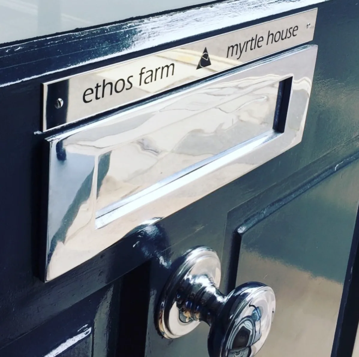 Navy front door with a polished chrome letter plate and an engraved Ethos Farm nameplate, Ethos HQ, London