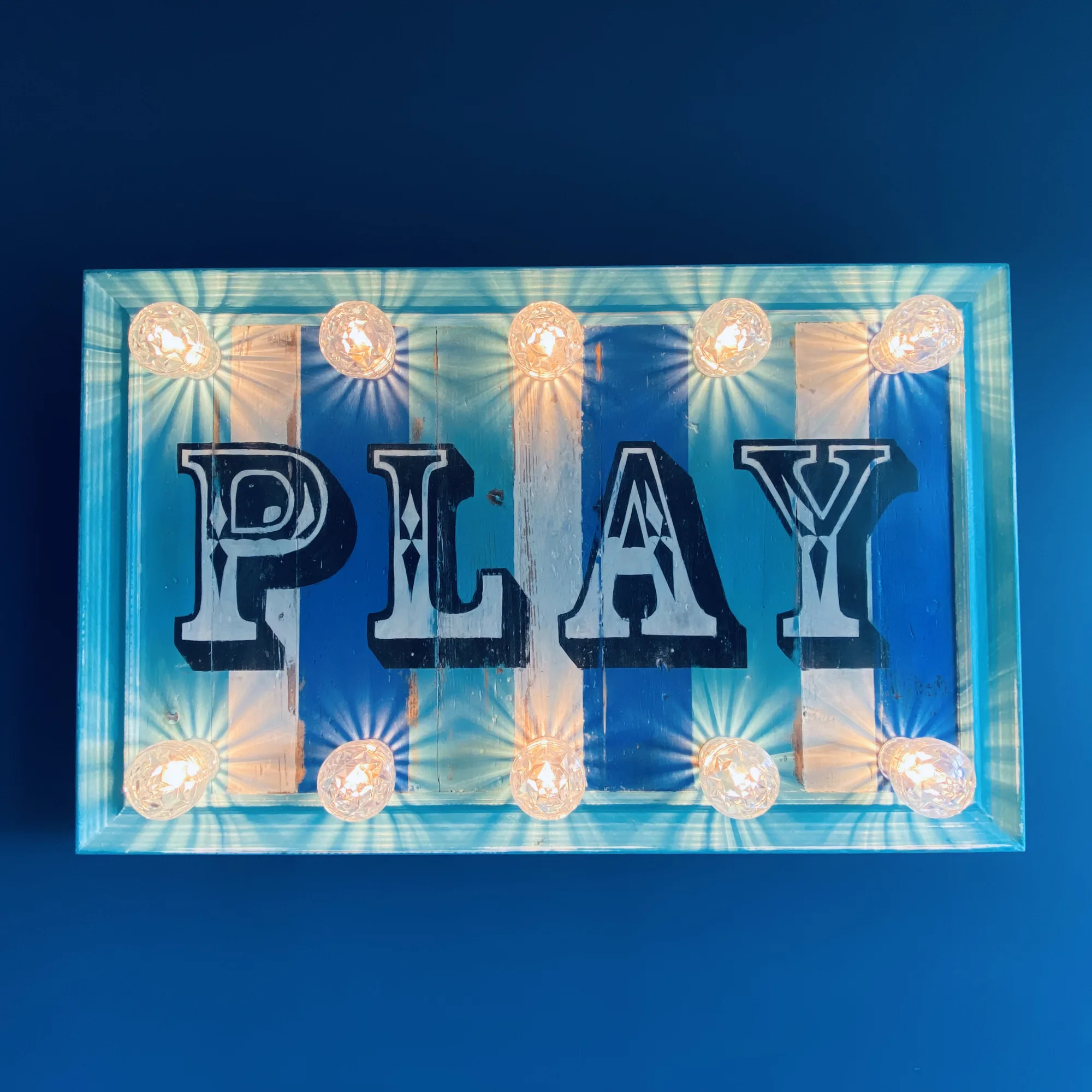 Illuminated vintage Play sign on the navy games room wall, Topsham, Devon