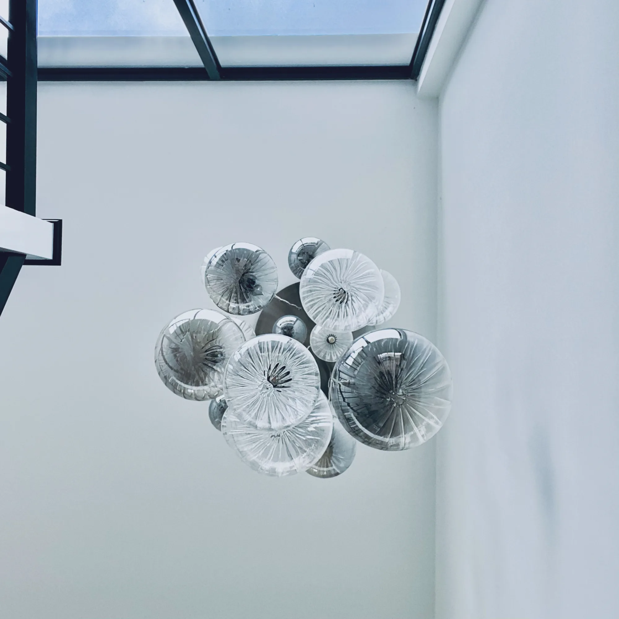 Franklite Perry glass cluster pendant hanging in the double height hallway, Topsham, Devon