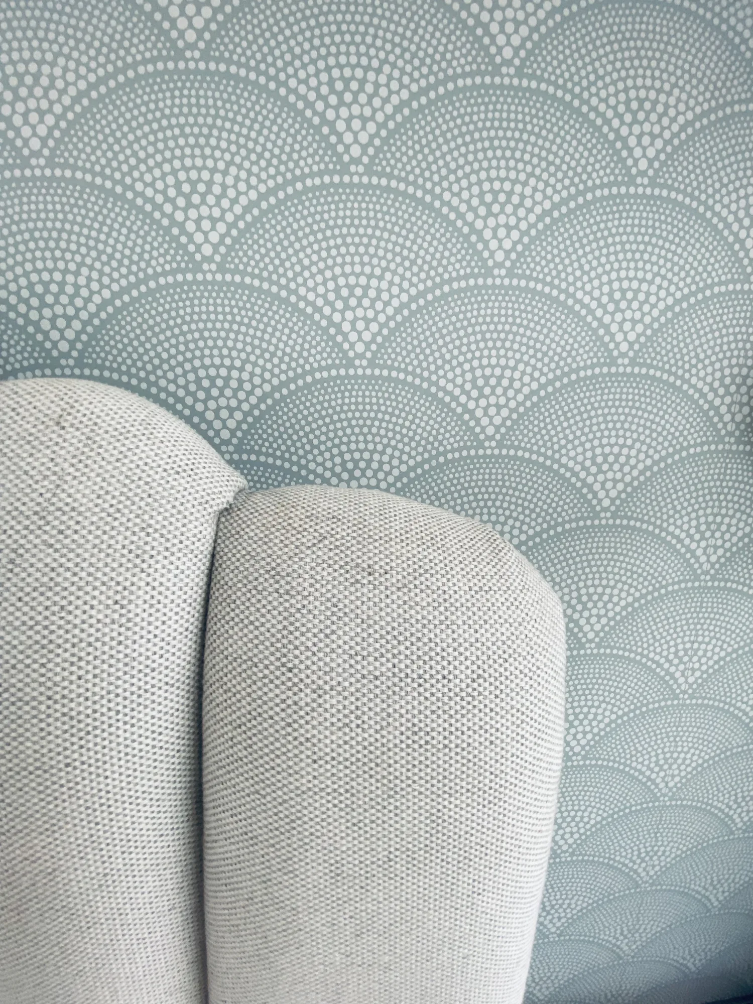 Scalloped upholstered bed head against scallop patterned wallpaper, Topsham, Devon